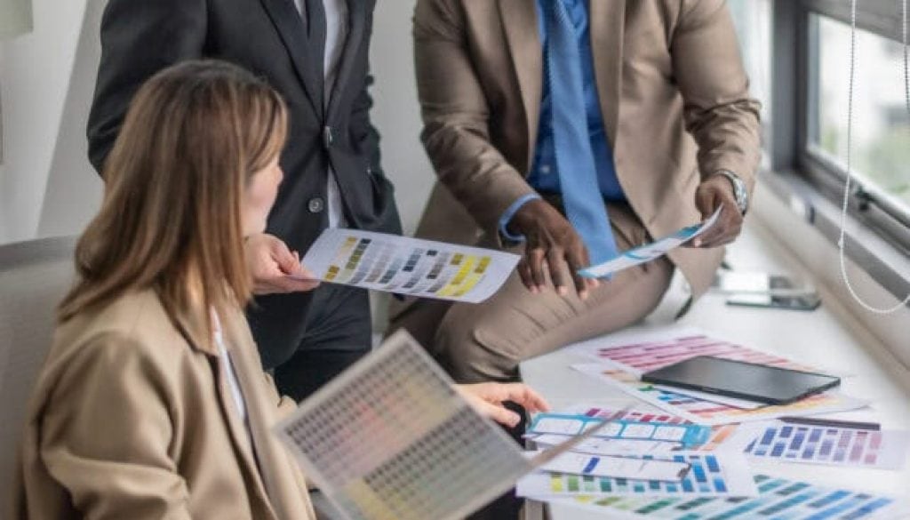 Business team discussing marketing materials in a modern office setting.