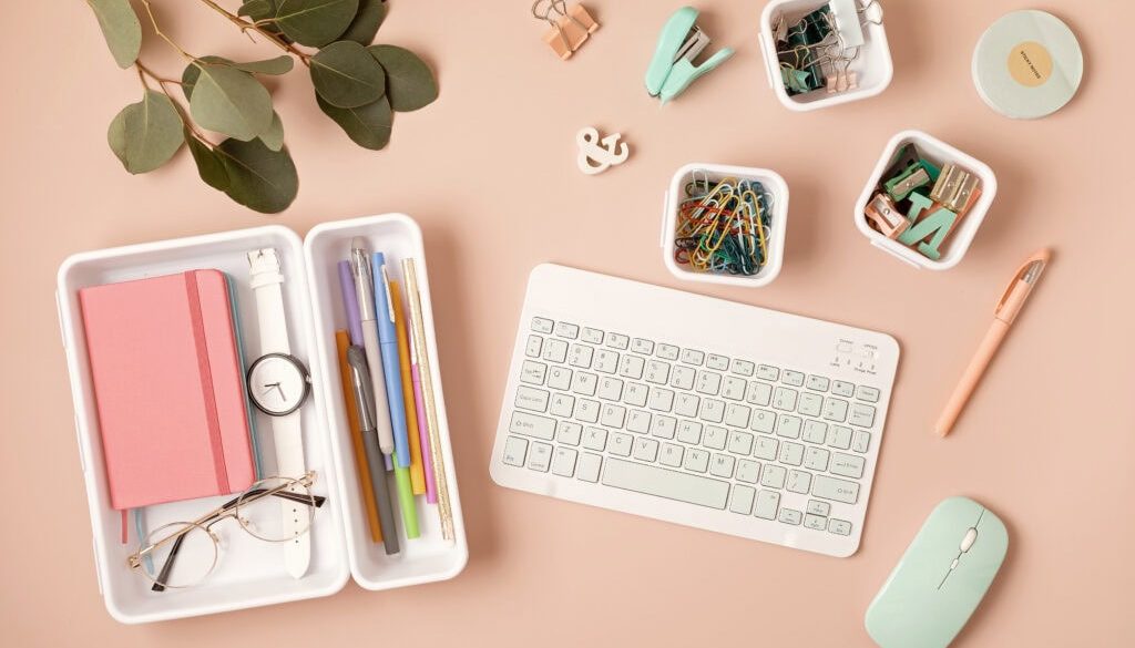 Office desk with stationery, keyboard, mouse, and plants for workspace organization.
