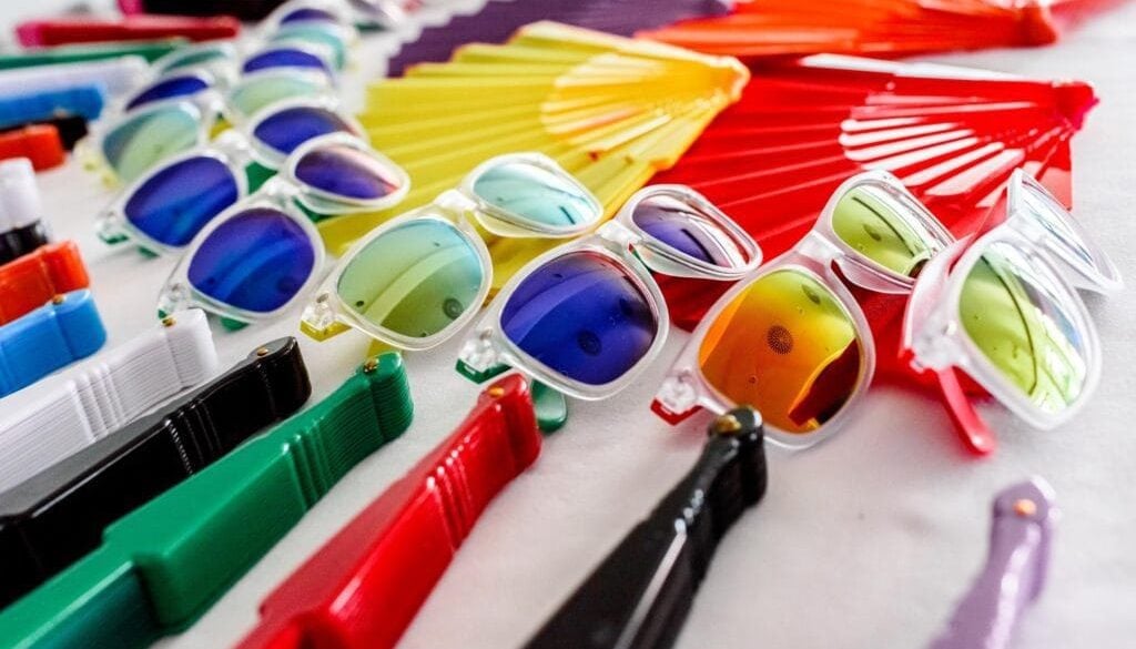 Assorted sunglasses and markers for promotional branding and giveaways.
