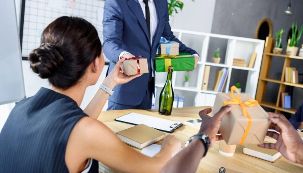 businessman presenting gifts to colleagues