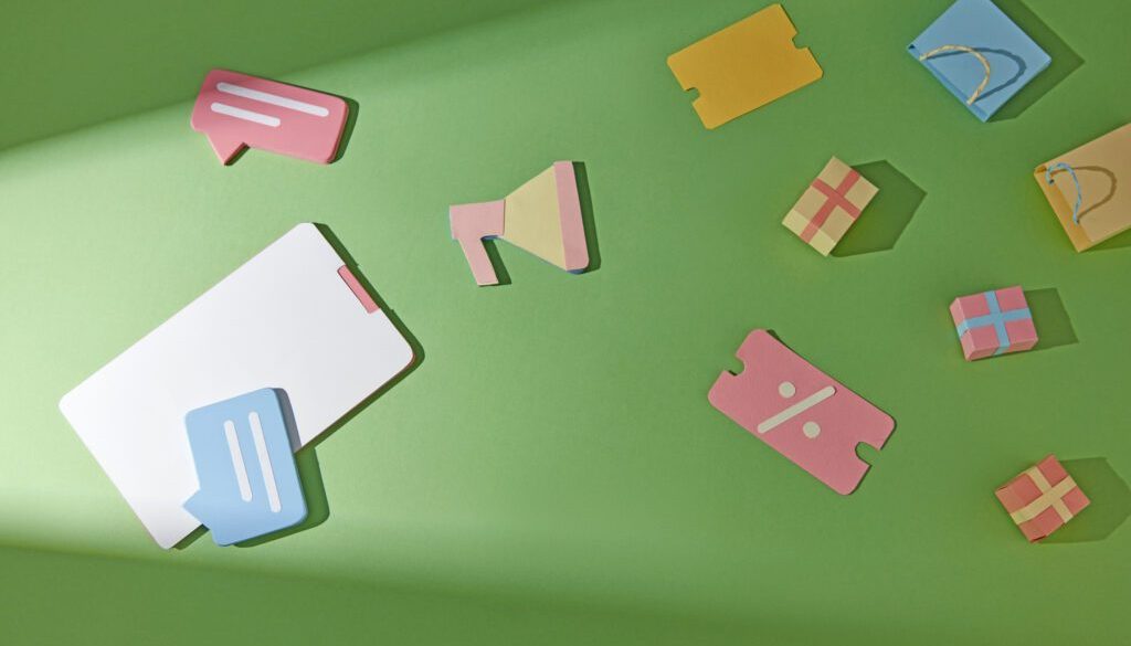 Colorful paper icons on a green background representing communication and shopping.