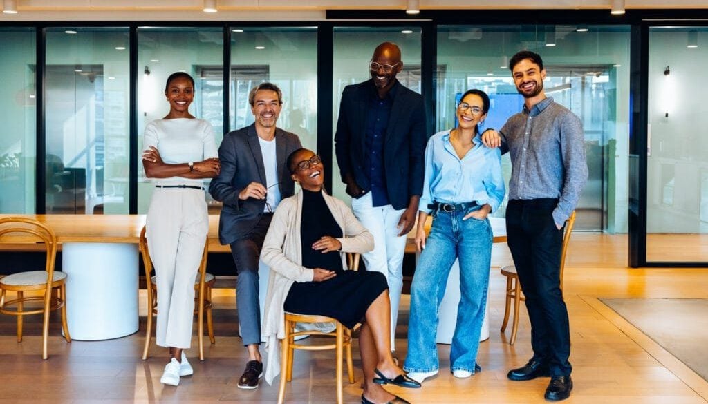 Diverse group of professionals smiling in modern office space.
