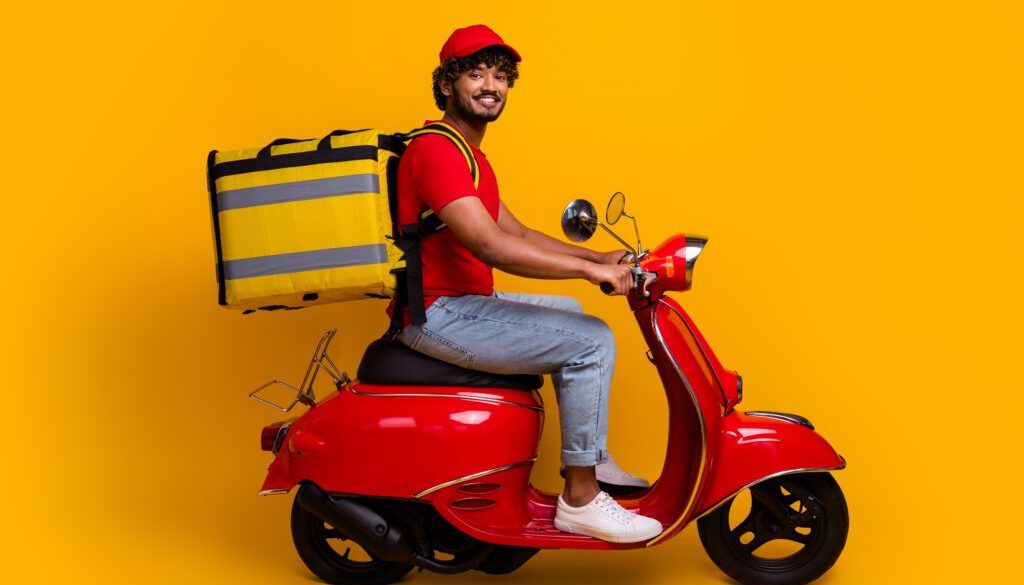 Courier wearing a red outfit delivering packages on a red scooter against a vibrant yellow background