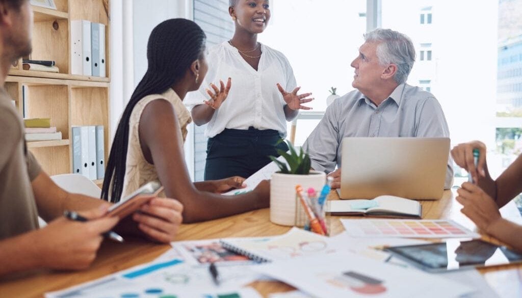 Black woman doing business presentation in meeting at work discussion about marketing strategy with team and collaboration on finance project Corporate employees in training and coaching workshop