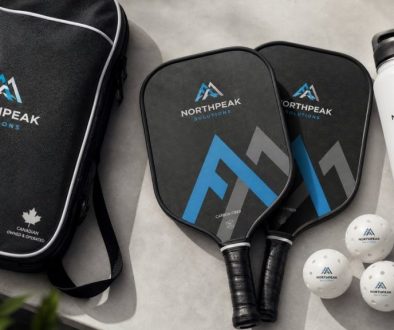 Branded corporate pickleball paddles, custom balls, carry case, and water bottle for a Canadian business tournament